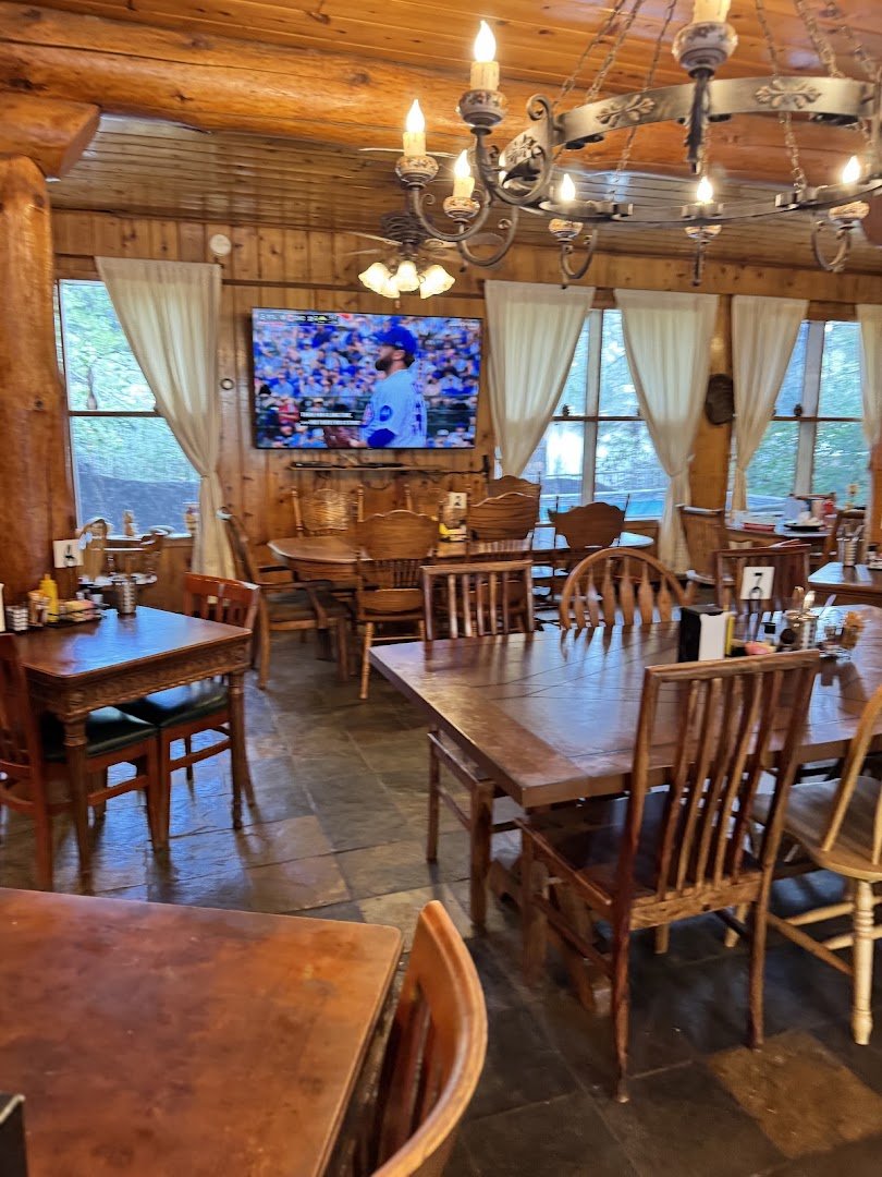 Tavern tables set beside a glowing fireplace.
